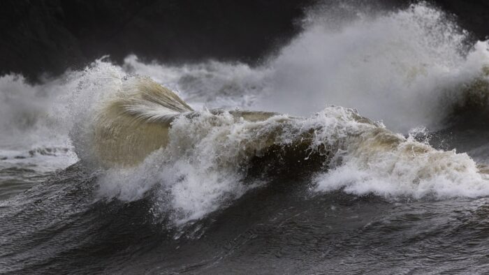 Powerful ocean waves crashing during a storm, illustrating a hurricane dream, storm surge, evacuation anxiety, and emotional overwhelm