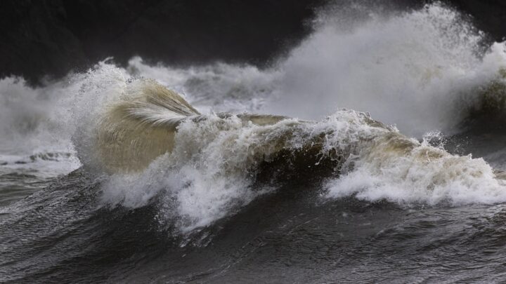 Powerful ocean waves crashing during a storm, illustrating a hurricane dream, storm surge, evacuation anxiety, and emotional overwhelm